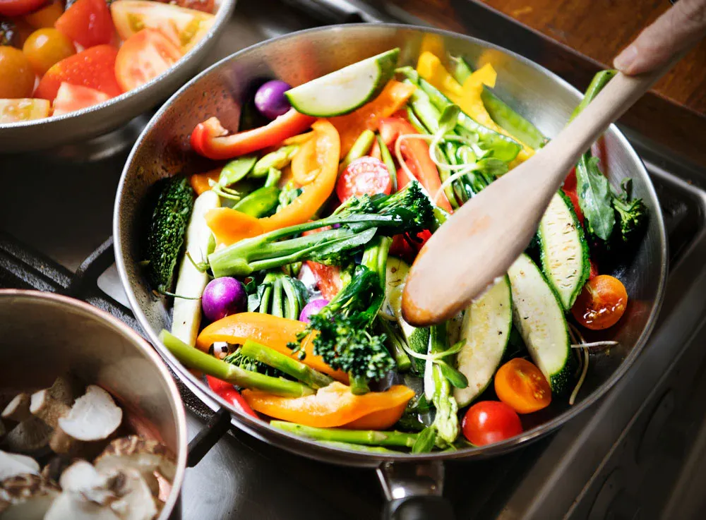 Pan of colorful sautéed vegetables, illustrating a healthy, balanced diet for runners